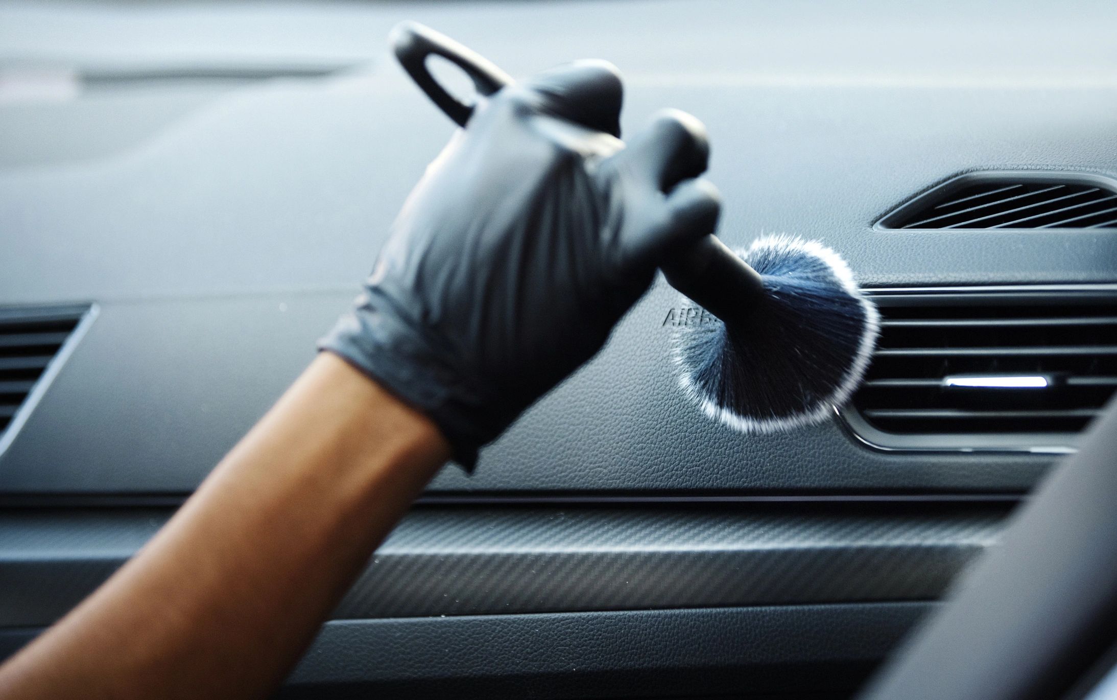 Detailing technician polishing car paint